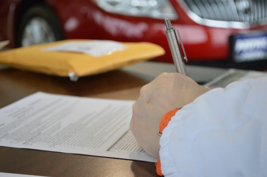 Hand filling in a first-time passport application at a desk