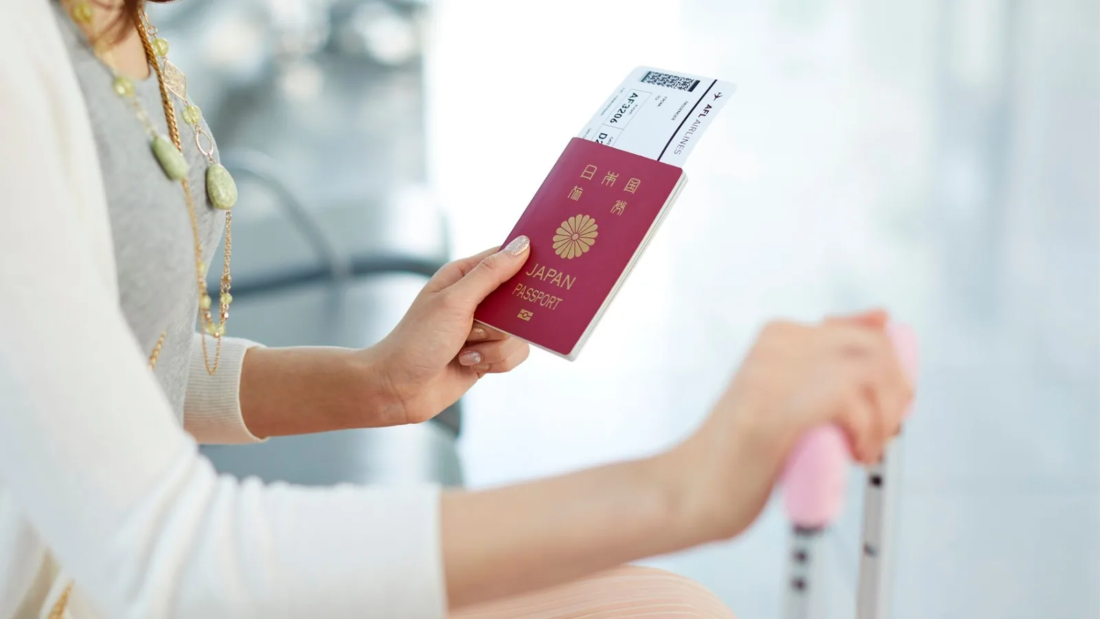 Traveller holding a passport and boarding pass with luggage