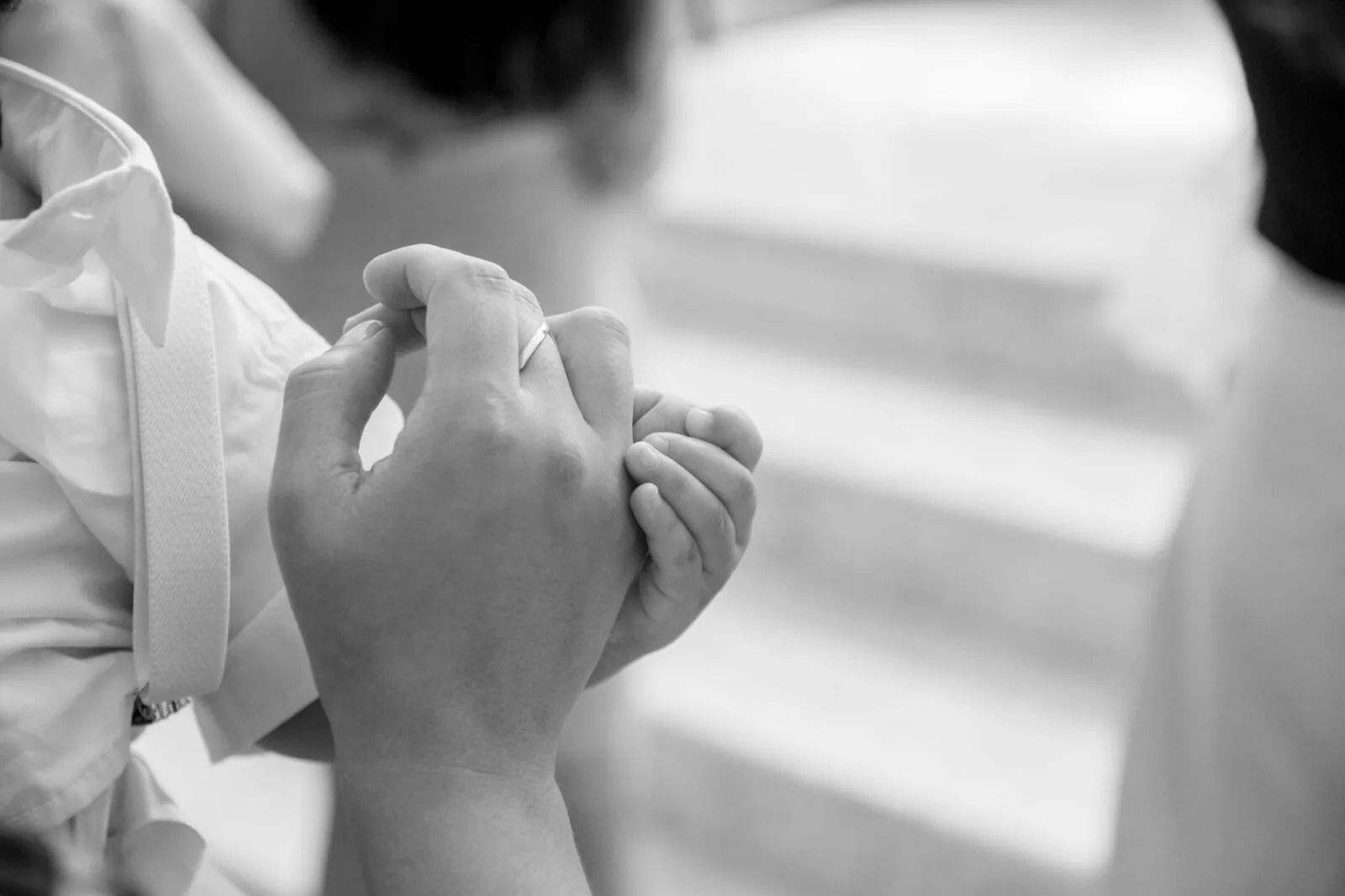 A parent holding a newborn baby’s hand