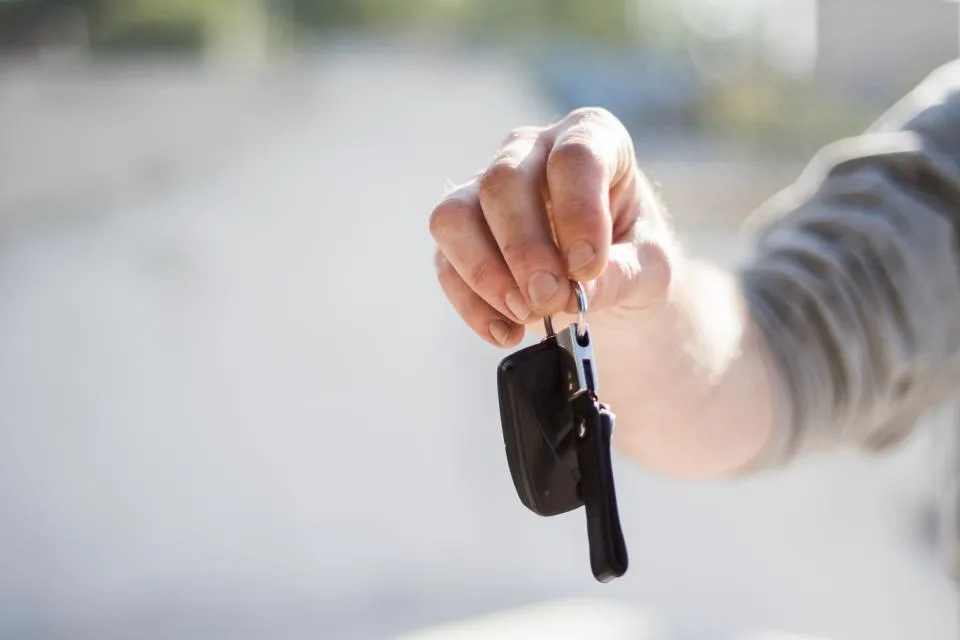 Car keys being handed over after a vehicle ownership transfer