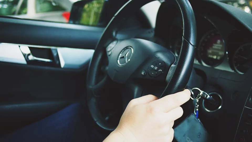 Driver starting a car with the key in the ignition